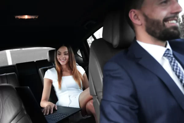 Female entrepreneur working during travelling to office in a luxury car.